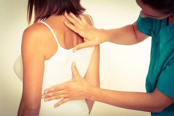 a doctor examines the back for thoracic osteoporosis